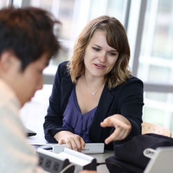 woman helping man on computer