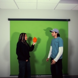 two people in front of a green screen